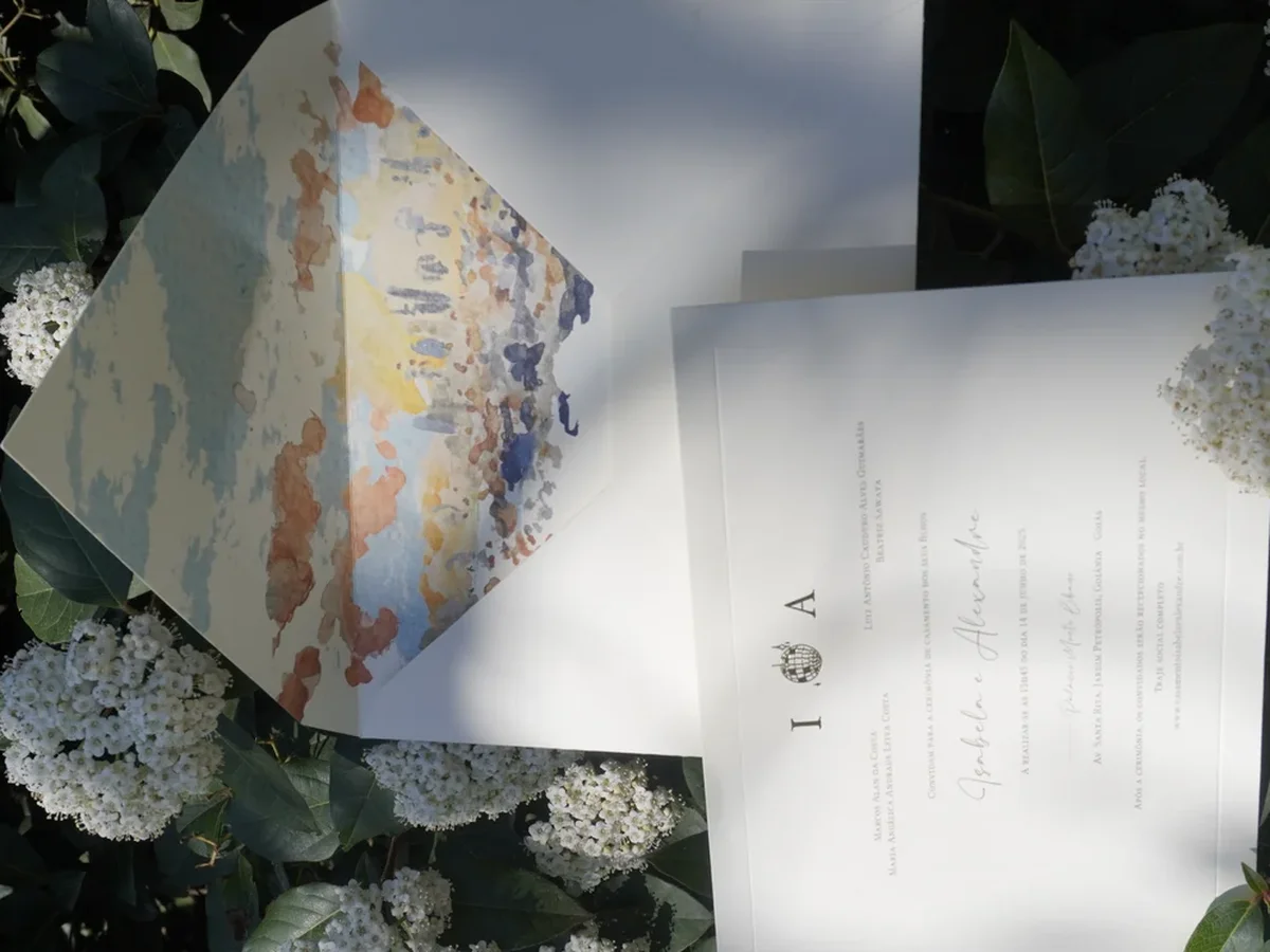 Printed wedding invitation with monogram and hand-painted sunset sky envelope liner